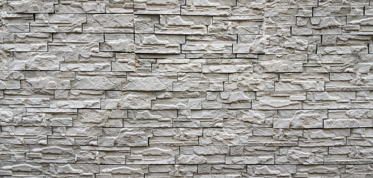 Hoge natuurstenen muur in moderne woning.